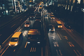 Night traffic on busy Asian city highway with trucks and cars