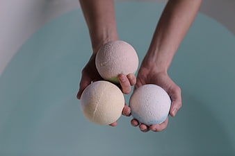Hands Holding Three Pastel Bath Bombs