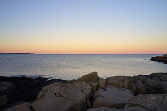 Serene Sunset Over Rocky Coastal Shoreline