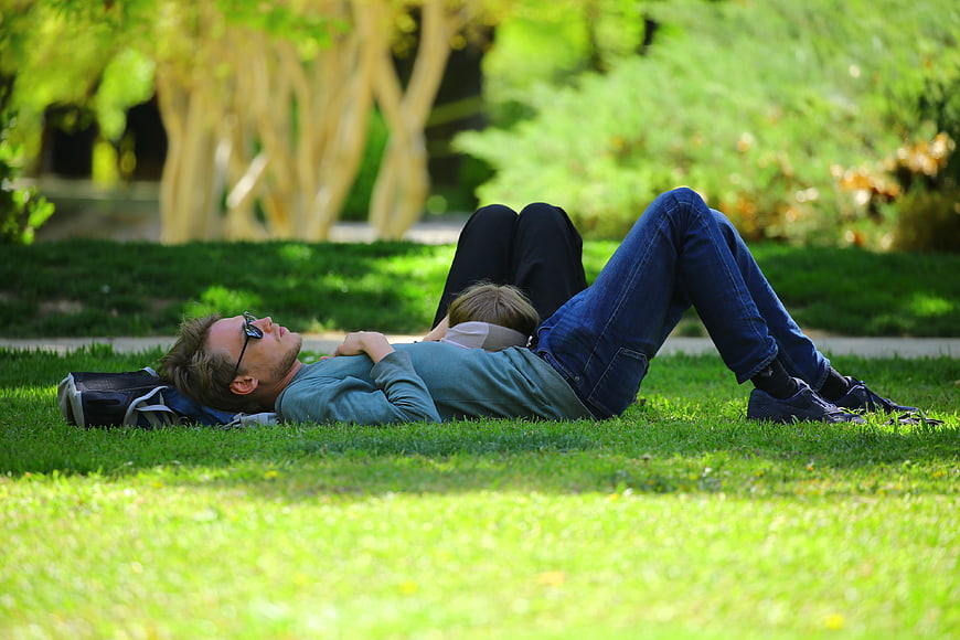 Couple relaxing on grass in sunny park