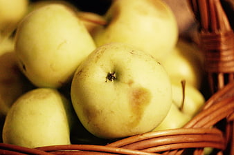 Close-up of fresh green apples in a woven wicker basket