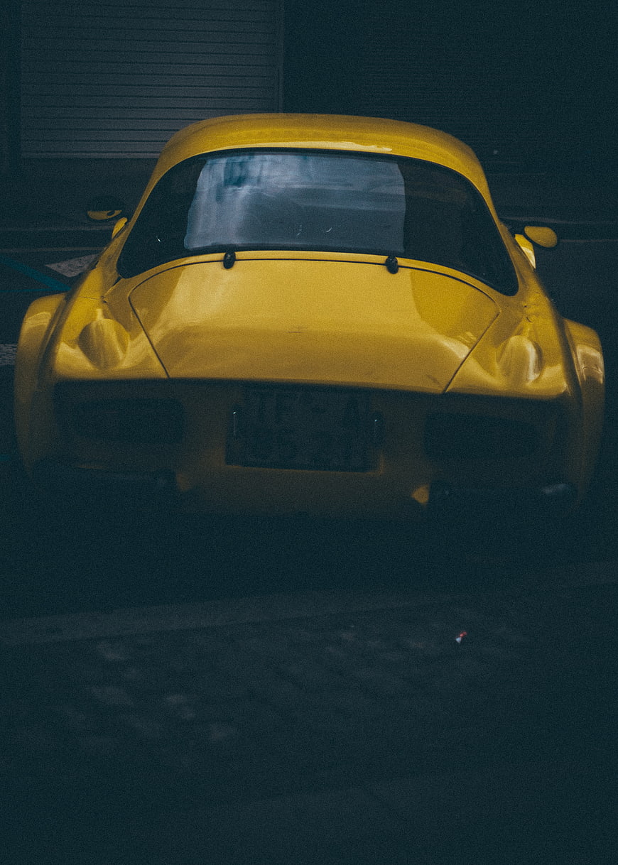 Rear view of classic yellow sports car at night