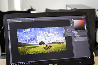 Laptop screen displaying landscape photo editing in Photoshop
