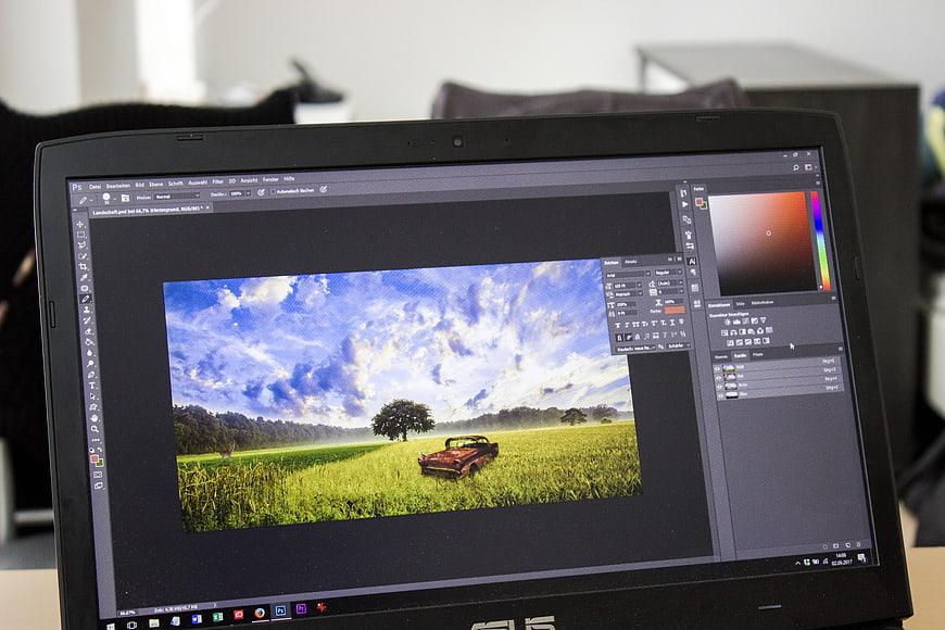 Laptop screen displaying landscape photo editing in Photoshop