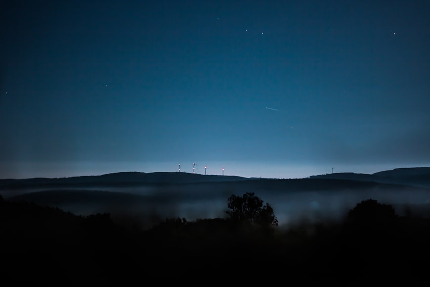 Misty Mountain Landscape at Night with Stars and Fog