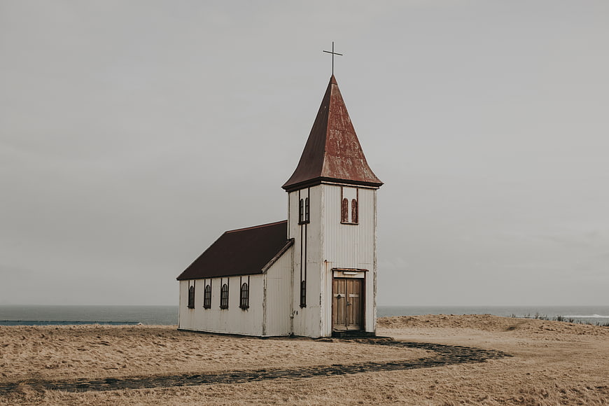 Solitary white church on sandy dunes by the ocean