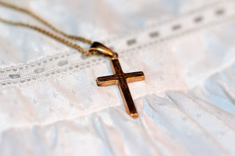 Gold Cross Necklace on White Lace Fabric
