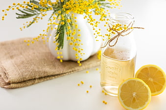 Fresh lemon detox drink with mimosa flowers and burlap