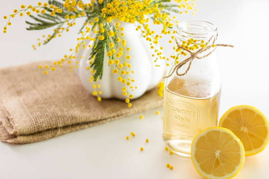 Fresh lemon detox drink with mimosa flowers and burlap