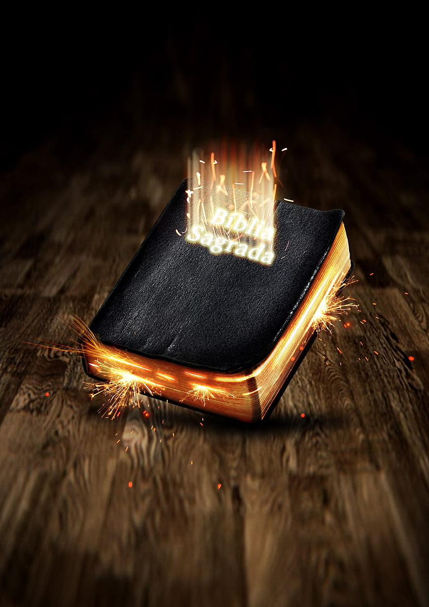 Glowing Holy Bible with Sparks on Wooden Background
