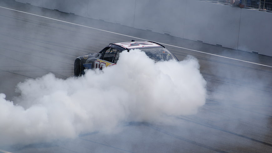 NASCAR race car performing a burnout on the track