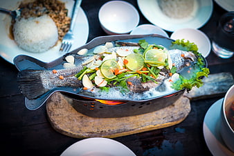 Steaming Whole Fish Dish With Lime And Herbs In Fish-Shaped Metal Pan