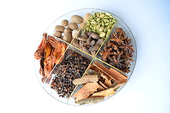 Assorted Whole Spices In Divided Glass Plate On White Background