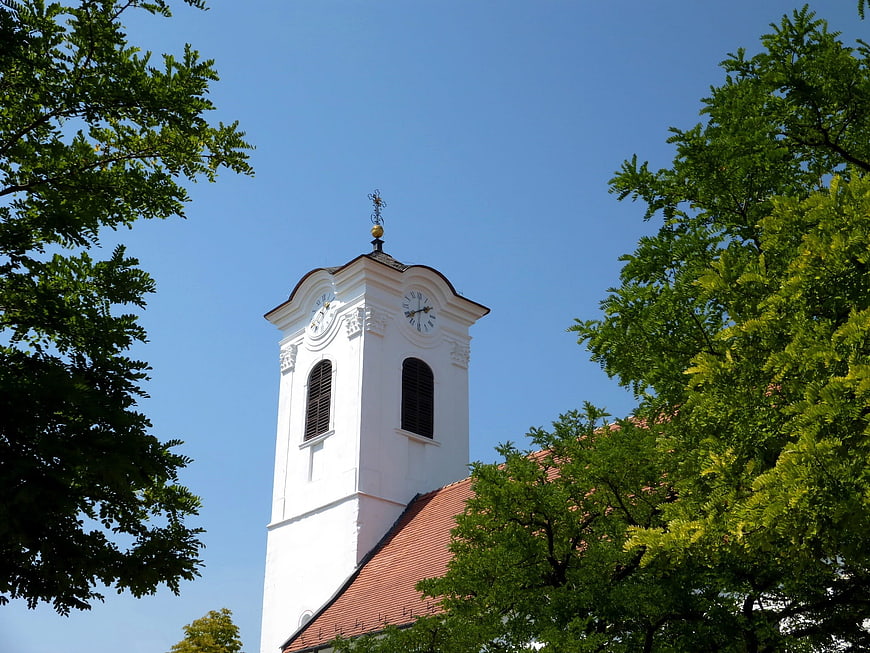 White church tower with clock against blue sky