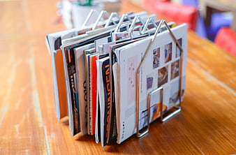 Magazine rack with brochures on wooden table
