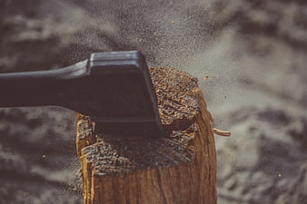 Black Axe Splitting Wood with Flying Sawdust