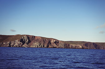 Dramatic coastal cliffs meeting deep blue ocean waters