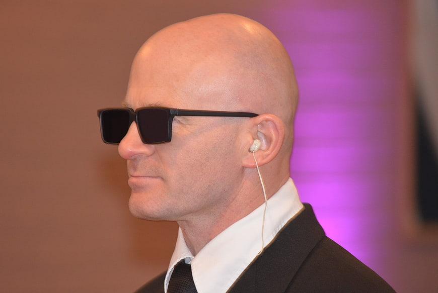 Bald man in suit and sunglasses with earpiece
