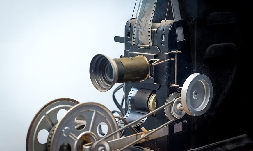 Vintage Film Projector Close-Up with Reels and Film Strip