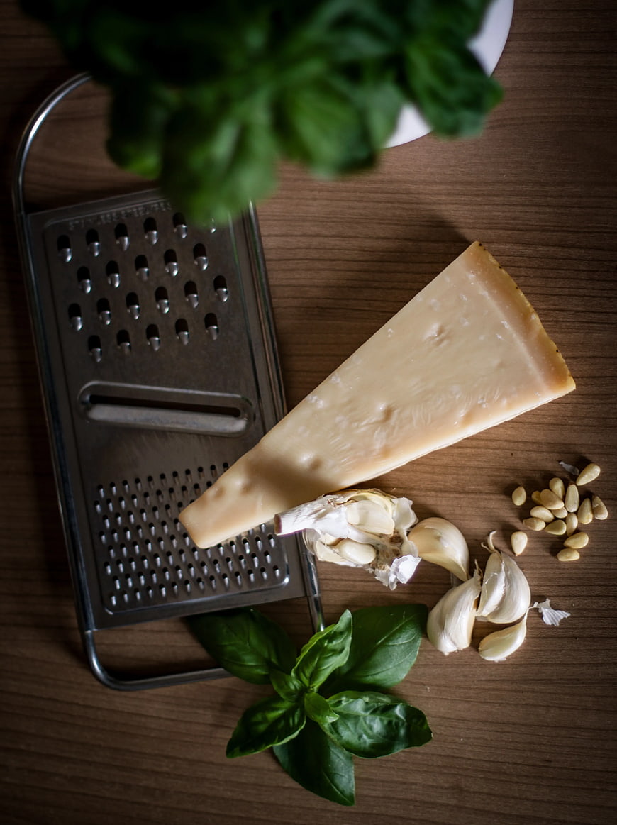 Parmesan Cheese, Garlic, Basil, and Grater on Wooden Table