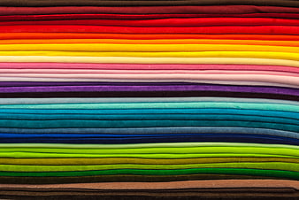 Stack of colorful folded fabrics in rainbow pattern