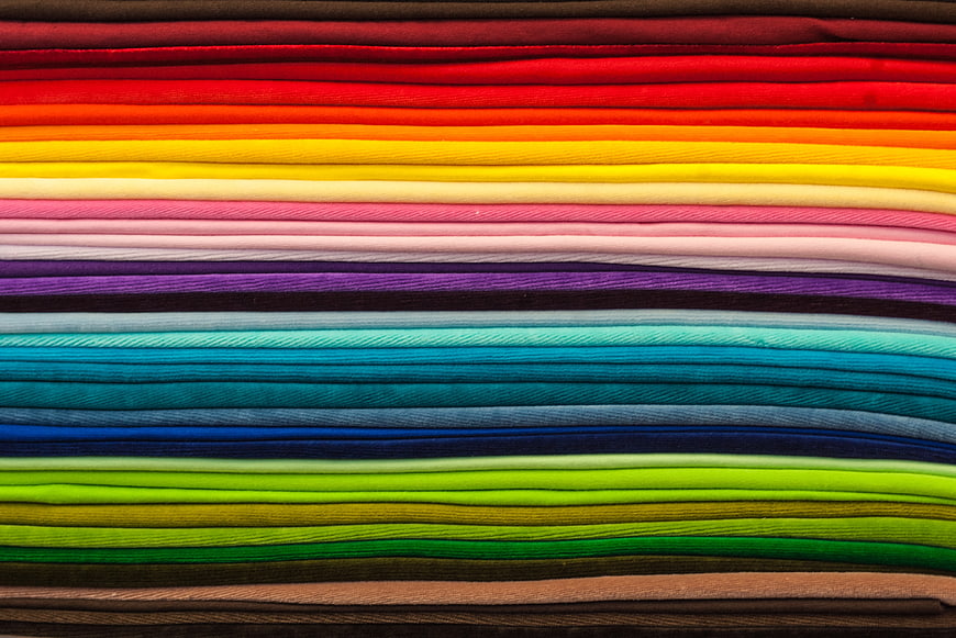 Stack of colorful folded fabrics in rainbow pattern