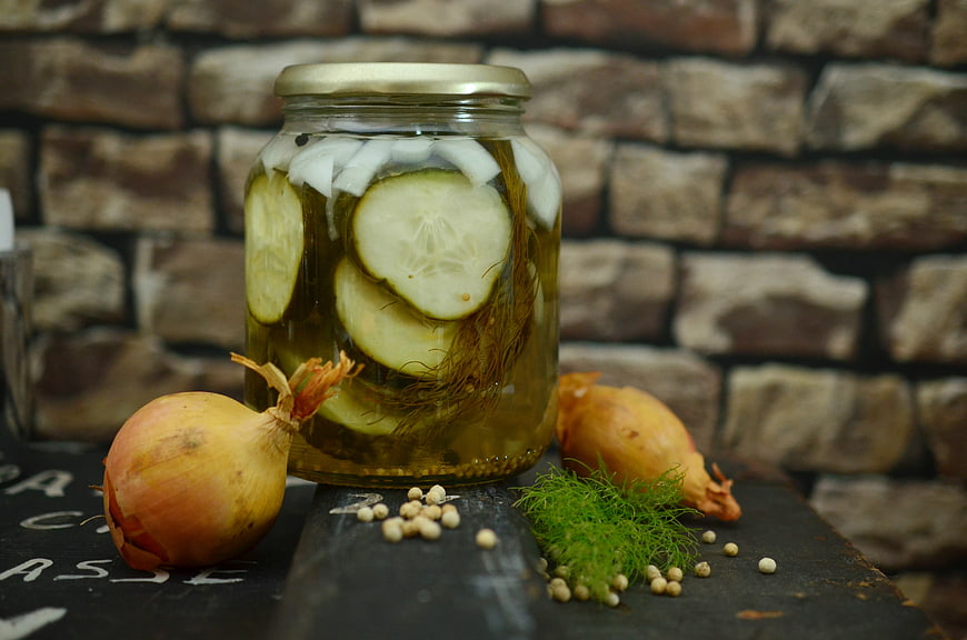 Homemade Pickled Cucumbers in Glass Jar with Onions and Dill