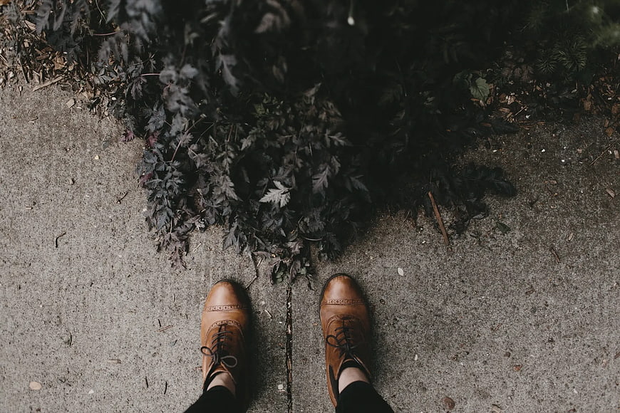 Top-down view of brown leather brogues on concrete