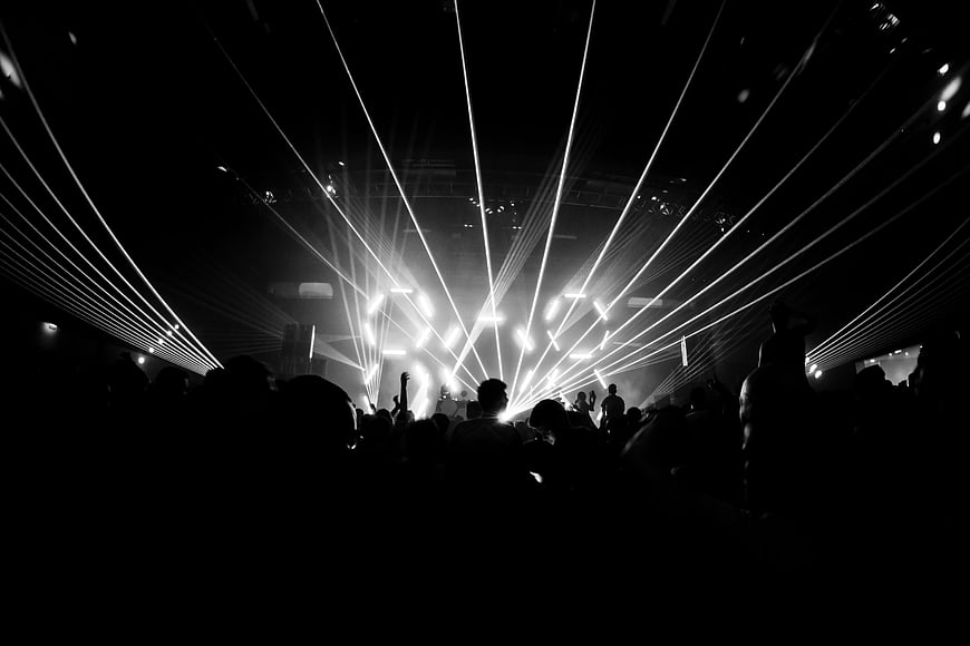 Black and white laser light show at a crowded music concert