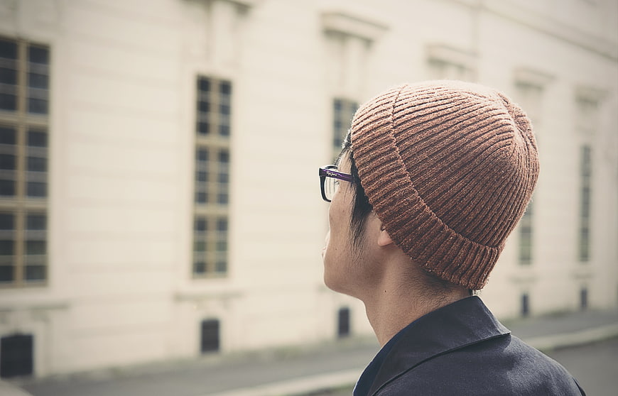 Man in Brown Beanie Looking at Building