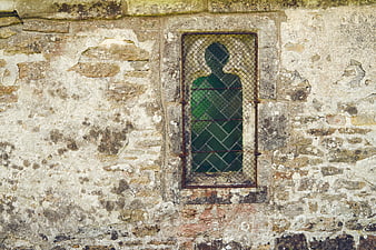 Silhouette of religious figure in stained glass church window