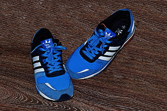 Blue Adidas sneakers on wooden floor