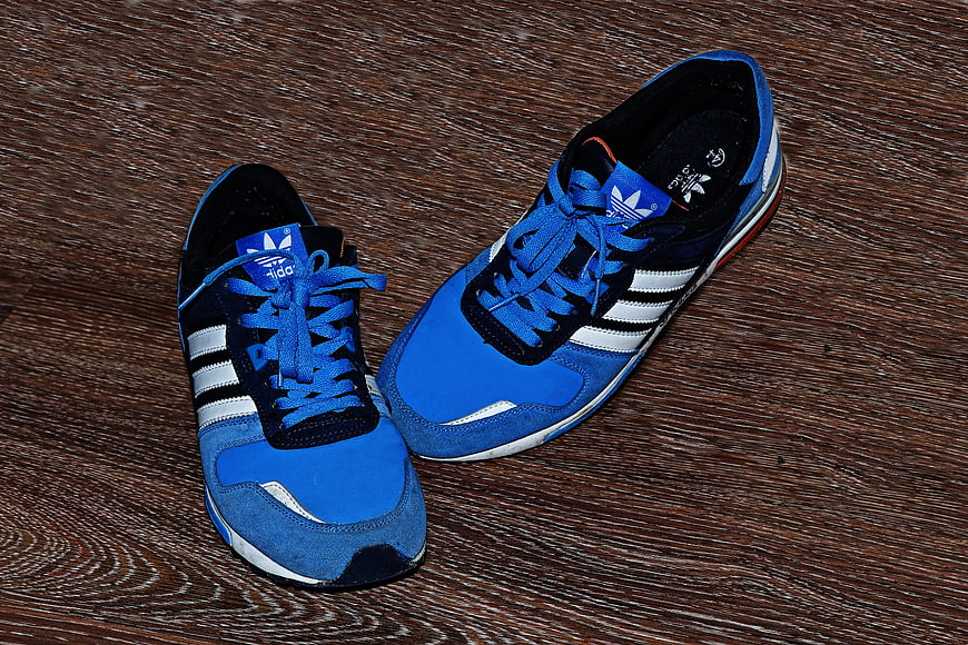 Blue Adidas sneakers on wooden floor