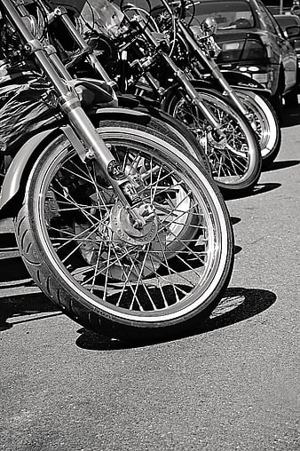 Black and white row of vintage motorcycles parked on asphalt