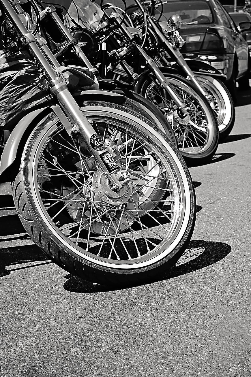 Black and white row of vintage motorcycles parked on asphalt
