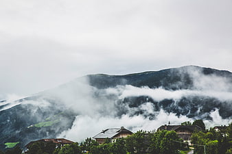 Misty mountain landscape with houses and fog