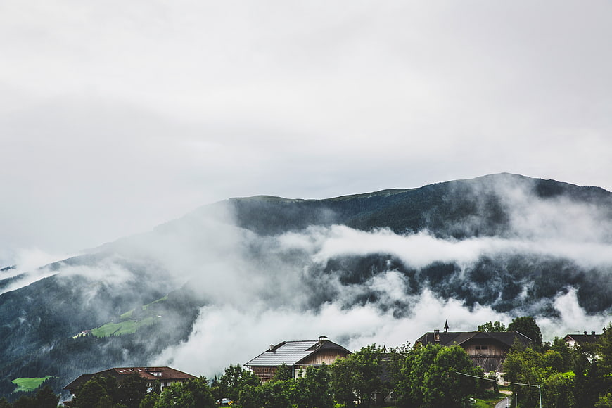Misty mountain landscape with houses and fog