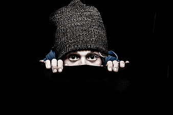Child Peeking Over Black Barrier Wearing Knit Beanie