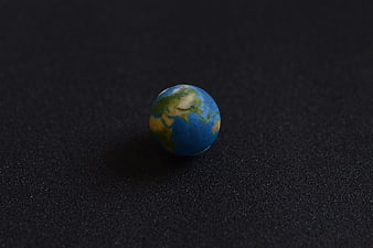 Small Earth Globe Model on Black Textured Background