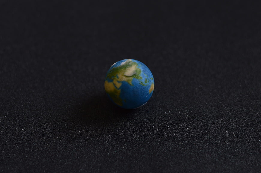 Small Earth Globe Model on Black Textured Background