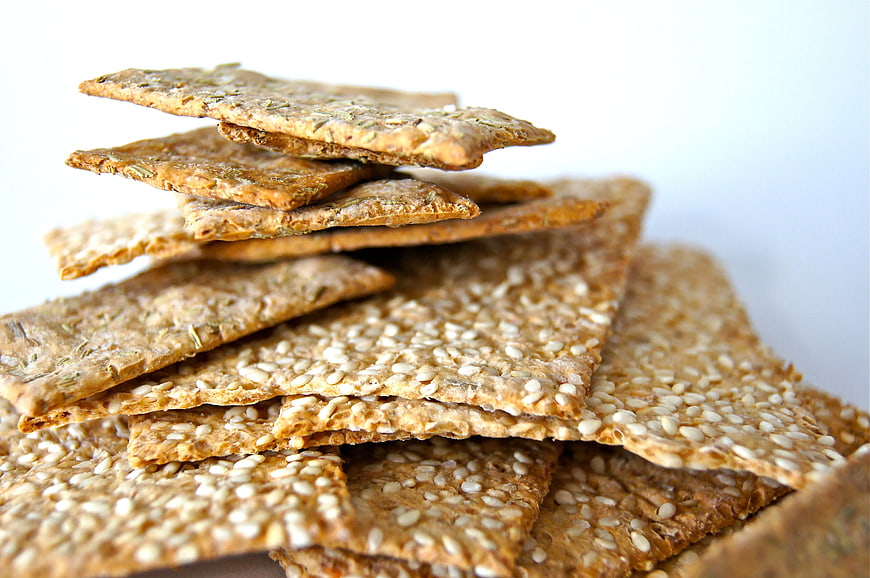 Stack of Sesame and Herb Crackers on White Background