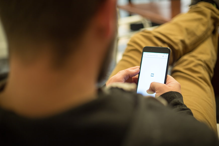 Man Using Smartphone While Sitting Down