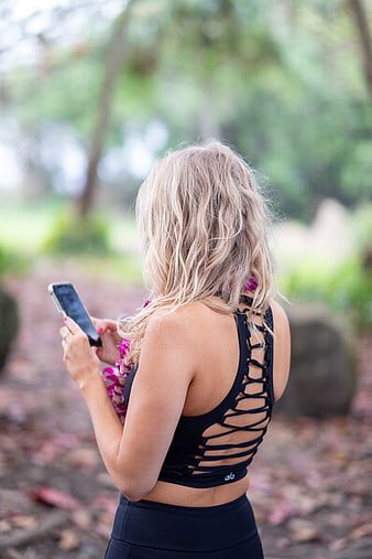 Blonde Woman in Black Sports Bra Using Smartphone Outdoors