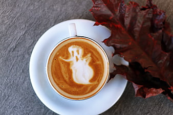 Top view of latte art ghost with autumn leaf