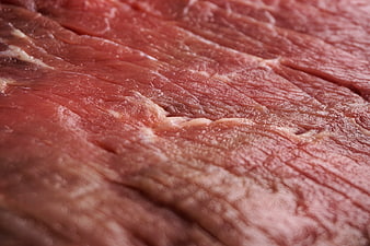 Close-up of raw red meat texture with visible grain and marbling