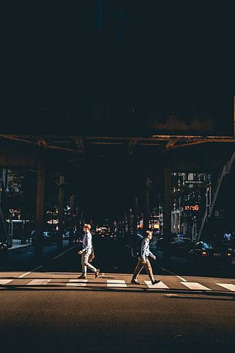 Two Men Walking Under Elevated Train Tracks at Night