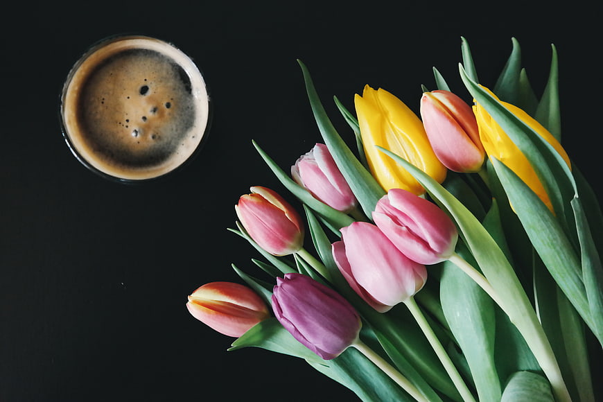 Top View of Tulips and Coffee on Black Background