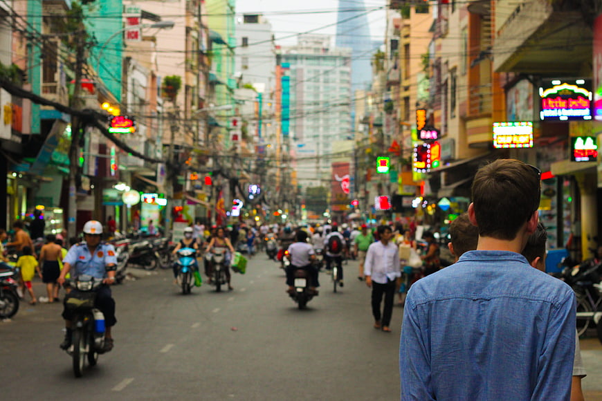 Busy Asian Street Scene with Motorbikes and Tourist