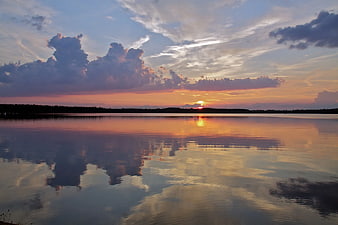 Serene Sunset Reflection on Calm Lake with Clouds