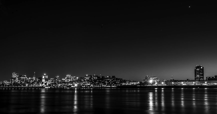 Black and White City Skyline at Night with Water Reflections
